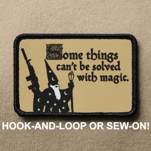 May include: A black and white patch featuring a wizard holding a staff and a rifle. The text on the patch reads "Some things can't be solved with magic."