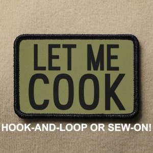 Può includere: Una toppa verde e nera con il testo "LET ME COOK" in lettere nere. La toppa è progettata per essere fissata con velcro o cucita.