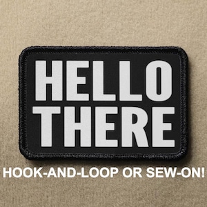 May include: Black rectangular patch with the words "HELLO THERE" in bold white letters. The patch has a black border and the text "HOOK-AND-LOOP OR SEW-ON!" below the main text.