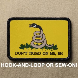 Puede incluir: Un parche amarillo con borde negro presenta un dibujo animado de un ganso con una serpiente envuelta alrededor de su cuerpo. El texto "DON'T TREAD ON ME, EH" está impreso debajo de la imagen. El parche está etiquetado como "HOOK-AND-LOOP OR SEW-ON!"