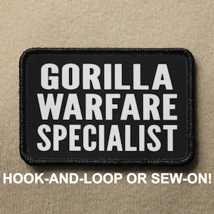 Puede incluir: Parche rectangular negro con texto blanco "GORILLA WARFARE SPECIALIST". El parche tiene un borde negro y el texto "HOOK-AND-LOOP OR SEW-ON!" debajo. El parche está sobre un fondo beige.