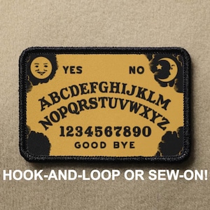 Könnte beinhalten: Ein rechteckiger Aufnäher mit gelbem Hintergrund und schwarzem Rand. Der Aufnäher zeigt ein Ouija-Brett-Design mit dem Alphabet, Zahlen und den Wörtern "YES", "NO" und "GOOD BYE". Der Text "HOOK-AND-LOOP OR SEW-ON!" steht unten.