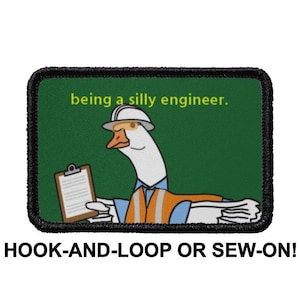 Könnte beinhalten: Ein grüner und schwarzer Patch mit einer Cartoon-Gans, die einen Helm trägt und eine Klemmbrett hält. Der Text "being a silly engineer." ist in Gelb auf dem Patch geschrieben. Der Patch ist mit "HOOK-AND-LOOP OR SEW-ON!" beschriftet.