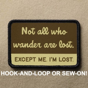 May include: A brown patch with black stitching features the text "Not all who wander are lost. EXCEPT ME. I'M LOST." in a yellow font. The patch is for hook-and-loop or sew-on attachment.