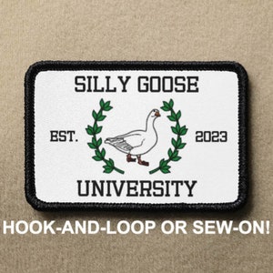 以下が含まれることがあります： 黒い縁取りのある白いパッチで、緑色の輪の中に白いガチョウが描かれています。黒い文字で「SILLY GOOSE UNIVERSITY」と印刷されており、ガチョウの下には「EST. 2023」とあります。このパッチは、フックとループまたは縫い付け用です。
