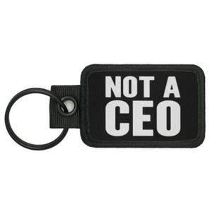 May include: Black key chain with a black patch that says "NOT A CEO" in white letters.