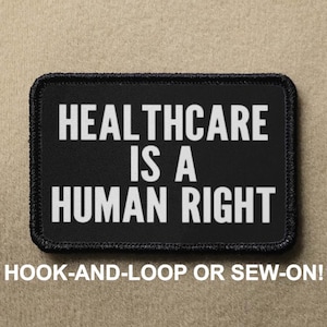 May include: Black patch with white text that reads "Healthcare is a Human Right". The patch has a hook and loop backing and can also be sewn on.