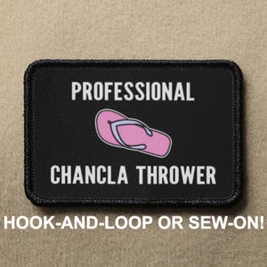 May include: Black rectangular patch with white text that reads "PROFESSIONAL CHANCLA THROWER". A pink and purple flip-flop graphic is in the center. The text "HOOK-AND-LOOP OR SEW-ON!" is at the bottom.
