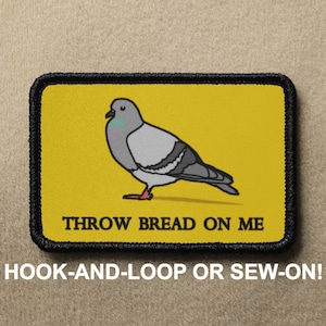 May include: A yellow patch with a black border features a cartoon gray pigeon with pink feet and the text "THROW BREAD ON ME". The patch is labeled "HOOK-AND-LOOP OR SEW-ON!"
