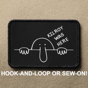 May include: Black rectangular patch featuring a white cartoon character and the text "KILROY WAS HERE". The patch has a black border and the text "HOOK-AND-LOOP OR SEW-ON!" is below. A humorous design.