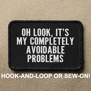 May include: Black patch with white text that reads "OH LOOK, IT'S MY COMPLETELY AVOIDABLE PROBLEMS". The patch is for hook-and-loop or sew-on attachment.