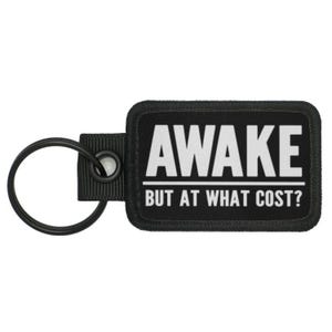 May include: Black key chain with a black rectangular tag that says "AWAKE BUT AT WHAT COST?" in white text.