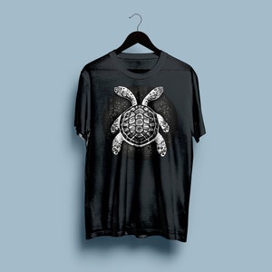 May include: Black t-shirt featuring a white graphic of a sea turtle against a starry background.