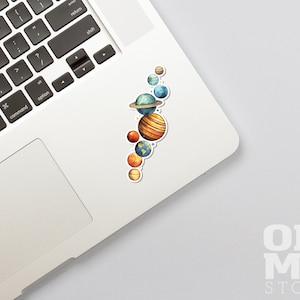 May include: A sticker featuring a watercolor illustration of the planets in our solar system. The planets are arranged vertically, with the sun at the top and the other planets below. The planets are painted in realistic colors, with details like rings and clouds.