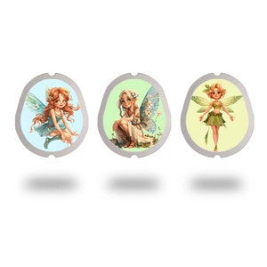 May include: Three round, silver-colored, decorative charms with images of fairies. Each charm features a different fairy with wings, a different colored dress, and a different background color. The first charm has a blue background with a fairy wearing a blue dress. The second charm has a green background with a fairy wearing a white dress. The third charm has a yellow background with a fairy wearing a green dress.