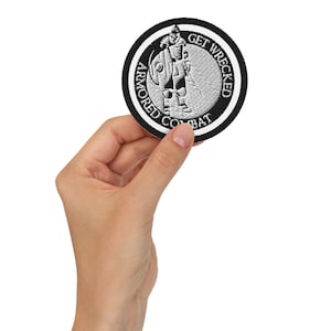 May include: A black and white embroidered patch with a knight figure and the text "Armored Combat Get Wrecked".