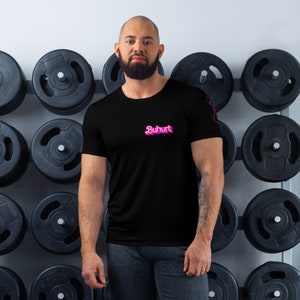 Könnte beinhalten: Ein schwarzes T-Shirt mit einem pinkfarbenen "Buhurt"-Logo auf der Vorderseite. Das Shirt wird von einer Person in einem Fitnessstudio getragen.