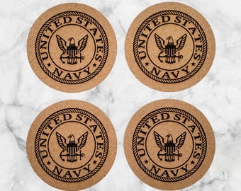 May include: Set of four cork coasters featuring the United States Navy seal. Each coaster is round and has a brown cork surface with a black seal design.