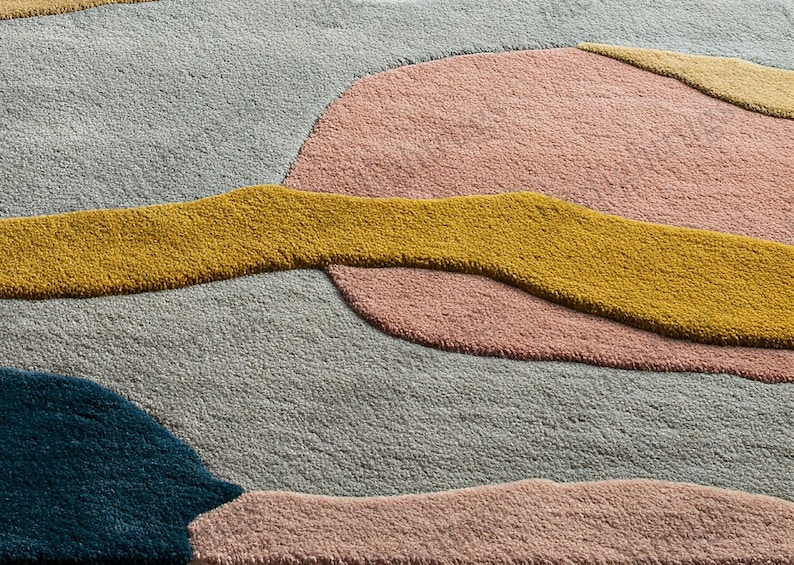 Modern artistic area rug in mustard, teal, pink, and neutral tones