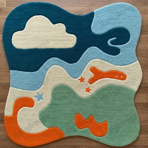 May include: A colorful, abstract rug with a cloud, waves, stars, and fish shapes. The rug is made of soft, plush material and is perfect for a child's room.