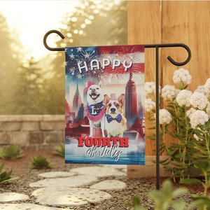 Op de afbeelding: Een rood, wit en blauwe tuin vlag met twee honden en de tekst "Happy Fourth of July".