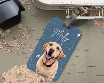 May include: A blue luggage tag featuring a smiling yellow Labrador Retriever with the name "Molly" in white script. The tag has a travel theme with airplane icons and dotted lines. A red collar is visible.