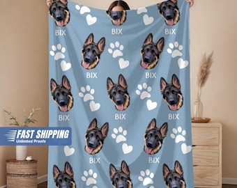 May include: A light blue blanket featuring repeating images of a German Shepherd's face, white paw prints, and hearts. The word "BIX" is printed below each dog image. The blanket is a pet-themed item.