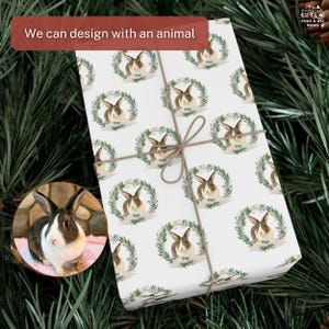 Op de afbeelding: Wit cadeaupapier met een herhaald patroon van konijnen in groene kransen, vastgebonden met touw. Een kleine inset-afbeelding toont een bruin en wit konijn. De tekst op het cadeaupapier luidt "Pips". De tekst "We can design with an animal" staat in een rode doos.