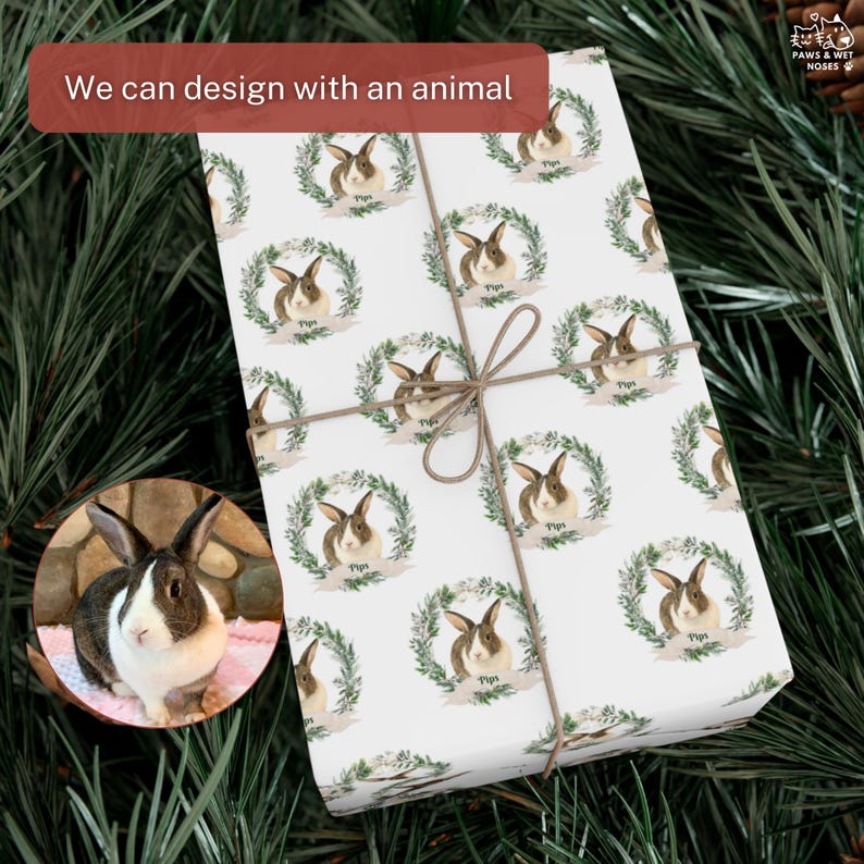 Op de afbeelding: Wit cadeaupapier met een herhaald patroon van konijnen in groene kransen, vastgebonden met touw. Een kleine inset-afbeelding toont een bruin en wit konijn. De tekst op het cadeaupapier luidt "Pips". De tekst "We can design with an animal" staat in een rode doos.