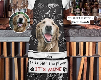May include: Black and white kitchen apron with a hand-drawn illustration of a golden retriever dog. The apron has a pocket with the name "Bailey" and the text "If It Hits The Floor It's Mine".