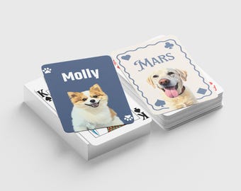 May include: A deck of playing cards featuring custom pet portraits. One card displays a dog named "Molly" on a blue background, while another card shows a dog named "Mars". The cards are stacked on a white surface.