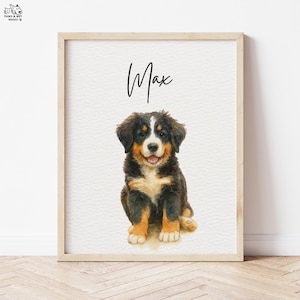 Op de afbeelding: Een ingelijste aquarelprint met een Berner Sennenhond puppy. De puppy heeft zwart, bruin en wit haar en zit met zijn tong uit. De naam "Max" staat in cursief boven de puppy.