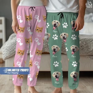May include: Pink pajama pants with a cat face pattern, white paw prints, and the name "Theo". Green pajama pants with a dog face pattern, white paw prints, and the name "Mars". Both have black drawstrings.