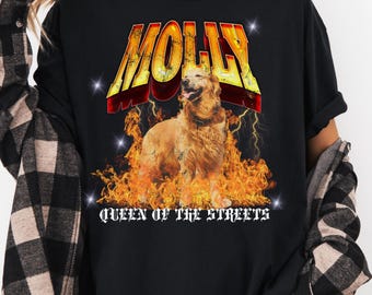 May include: Black t-shirt with a graphic of a golden retriever dog with the text "MOLLY QUEEN OF THE STREETS" in yellow and orange flames.