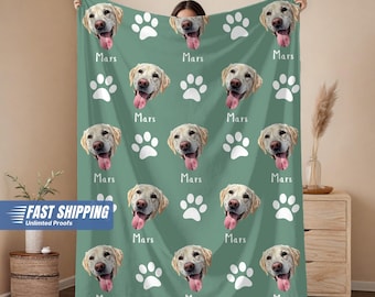 May include: A green blanket featuring a repeating pattern of dog faces, white paw prints, and the name "Mars". The blanket is made of a soft material and is designed for comfort and warmth.