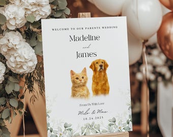 Op de afbeelding: Een welkomstbord voor een bruiloft op een houten ezel. Het bord luidt "Welkom bij de bruiloft van onze ouders" en bevat de namen "Madeline en James" met illustraties van een kat en een hond. Het bord bevat ook de tekst "From Us With Love Milo & Max 10.24.2025".