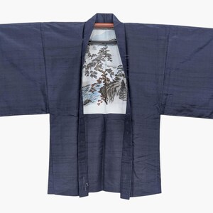 Peut inclure: Un kimono bleu marine foncé avec des manches larges et une doublure intérieure blanche ornée d'une illustration paysagère détaillée d'arbres, de rochers et d'un ruisseau. Le vêtement présente un col structuré et un tissu légèrement texturé.