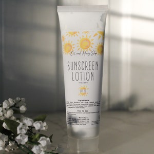May include: White sunscreen lotion bottle with a yellow and white sun design. The bottle is labeled "Oh and Honey Shop Sunscreen Lotion" and "SPF 30".