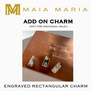 May include: Three silver engraved rectangular charms, each with a different letter: M, S, and W. The charms are displayed on a copper-coloured surface. Text includes "ADD ON CHARM" and "ENGRAVED RECTANGULAR CHARM".