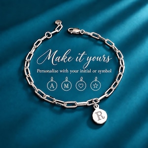 May include: A silver-toned chain link bracelet featuring a circular pendant engraved with the letter R. The text Make it yours, Personalise with your initial or symbol is displayed alongside icons of circular charms with A, M, a heart, and a star.