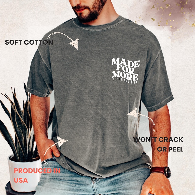 May include: A gray t-shirt with the text "MADE FOR MORE" and "EPHESIANS 2:10" printed on the back. The shirt is labeled "SOFT COTTON" and "WON'T CRACK OR PEEL". The shirt is labeled "PRODUCED IN USA".