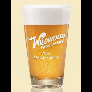 May include: A clear glass beer mug with a white foam head. The mug is filled with a golden yellow beer. The mug is decorated with the text "Wildwood New Jersey" and "The Lynch Family" in white.