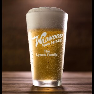 May include: A frosted glass of beer with condensation. The glass has a white logo that reads "Wildwood New Jersey The Lynch Family".