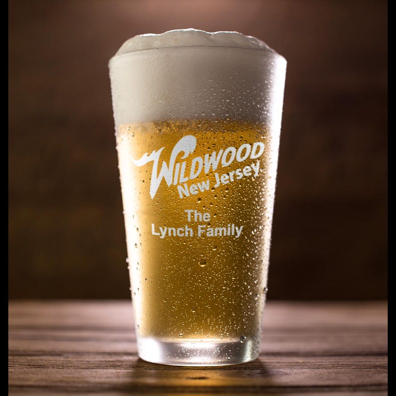 May include: A frosted glass of beer with condensation. The glass has a white logo that reads "Wildwood New Jersey The Lynch Family".