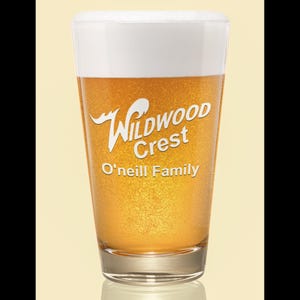 Peut inclure: Un verre &agrave; bi&egrave;re rempli de bi&egrave;re dor&eacute;e et surmont&eacute; d'une mousse blanche. Le verre porte l'inscription "Wildwood Crest" et "O'Neill Family" en blanc.