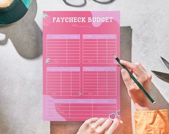 Op de afbeelding: Een roze en paarse printbare budgettracker met de titel "Paycheck Budget" en een aardbeienafbeelding. De tracker heeft secties voor inkomsten, rekeningen, besparingen, uitgaven en benodigdheden.