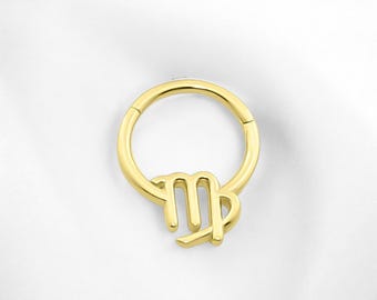 May include: Gold-toned Virgo zodiac sign charm attached to a gold-toned hoop earring.