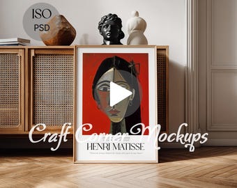 May include: A framed Henri Matisse art print featuring a portrait with a red background. The artwork is displayed on a wooden cabinet with woven panels, alongside decorative sculptures. The image includes the text "Craft Corner Mockups".