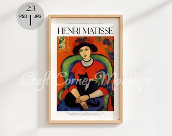 May include: A framed print of a painting by Henri Matisse, featuring a woman in a red dress and a black cat. The woman is sitting in a green armchair with a red and orange background. The text "HENRI MATISSE" is printed at the top of the frame.