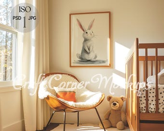 May include: A white bunny rabbit watercolor painting in a wooden frame hangs on a wall in a nursery. A white furry armchair with an orange pillow sits in the corner of the room. A wooden crib with a white and black polka dot sheet is in the background.